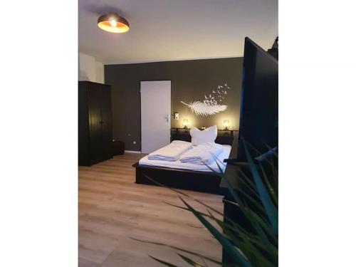 een slaapkamer met een bed met witte lakens en kussens bij 1 Raum-Ferienwohnung am Rosenberg in Goslar
