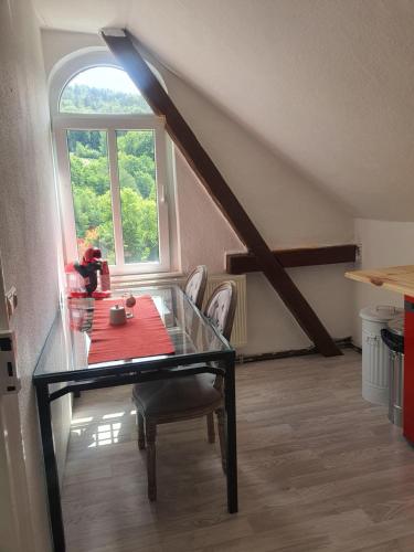 a dining room with a glass table and a window at Ferienwohnung Kirchblick in Königstein an der Elbe