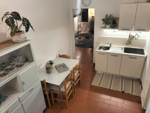 een keuken met een tafel met stoelen en een wastafel bij La tua casa nel Chianti in San Donato in Poggio