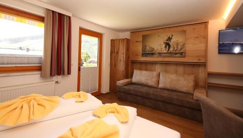 pokój hotelowy z 2 łóżkami i kanapą w obiekcie Hotel-Appartement Hochkönig w mieście Ramsau am Dachstein