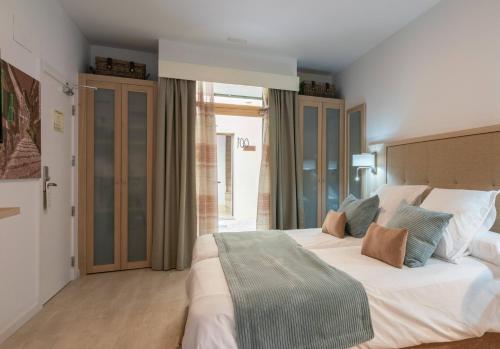 a bedroom with a large white bed and a window at Soller Plaza in Sóller