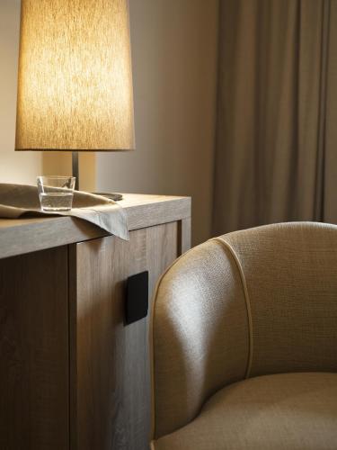 a chair sitting next to a table with a lamp at A.Roma Lifestyle Hotel in Rome