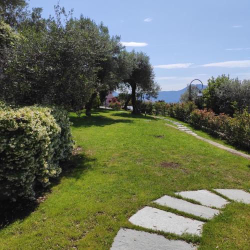 a garden with trees and grass and a pathway at Locanda Göghin in Pieve Ligure