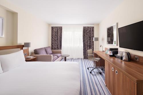 a hotel room with a bed and a desk and a tv at Holiday Inn Rochester-Chatham by IHG in Chatham
