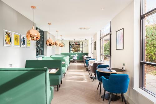 une salle à manger avec des chaises et des tables vertes dans l'établissement Holiday Inn Rochester-Chatham, an IHG Hotel, à Chatham