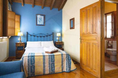 1 dormitorio con 1 cama con pared azul en Ca Pilarona El HorreoMallecina, en Salas