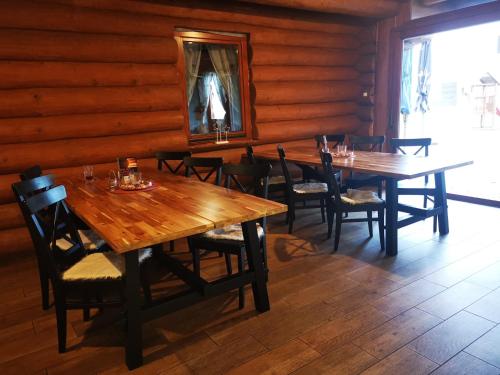a dining room with wooden tables and chairs and a mirror at Koliba Pod Skalami in Súľov-Hradná
