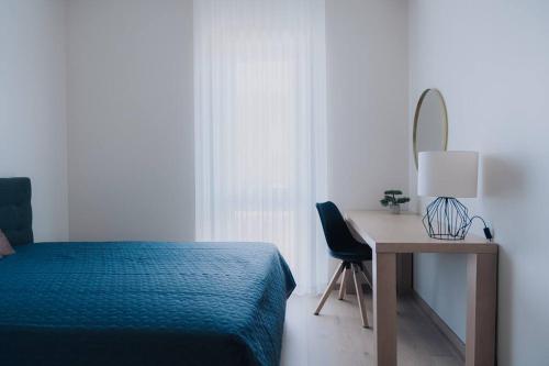 1 dormitorio con cama, escritorio y espejo en Vesiroosi Apartments - Apartment 3, en Pärnu