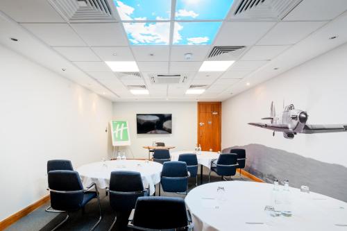 a conference room with tables and chairs and a ceiling at Holiday Inn Rochester-Chatham by IHG in Chatham
