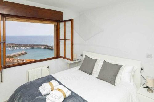 a bedroom with a bed and a large window at Mirador Del Puerto in Lastres
