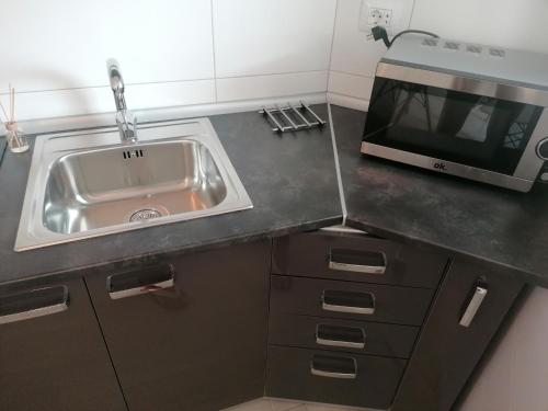 a kitchen with a sink and a microwave at summerland beach in Los Cristianos