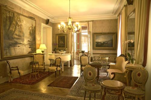 a living room with a table and chairs and a chandelier at Belle Isle Sur Risle - Chateau Hotel & Spa in Pont-Audemer