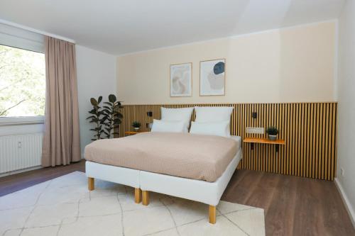 a white bedroom with a bed and a window at 80qm Luxuriöse Designerwohnung im Herzen Bochums in Bochum