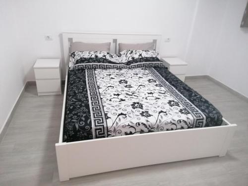 a white bed with a black and white comforter at summerland beach in Los Cristianos