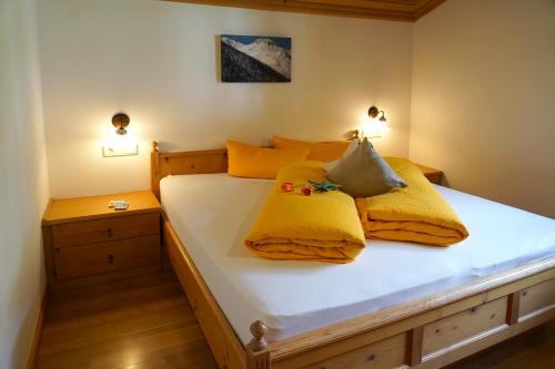 ein Schlafzimmer mit einem Bett mit gelben Decken und Kissen in der Unterkunft Sesvennahof in Mals im Vinschgau