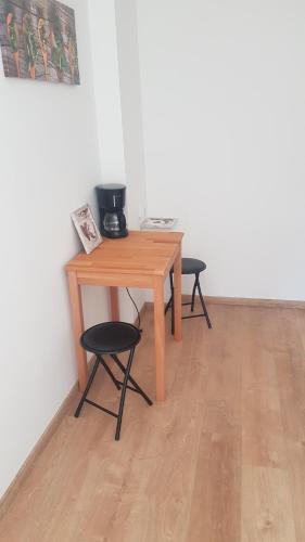 a wooden table and two chairs in a room at Ferienwohnung Mitte in Markkleeberg