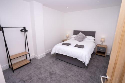 1 dormitorio con 1 cama blanca grande y espejo en A Beautiful 2 Bedroom Apartment with outdoor space, en Blackpool