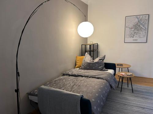 a bedroom with a bed and a lamp and a table at Apartment Wien West in Vienna