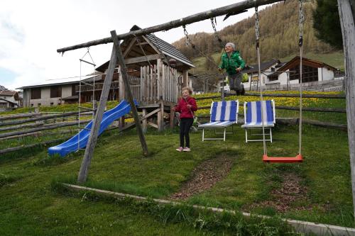 a woman and a child standing in a playground at Sesvennahof in Malles Venosta