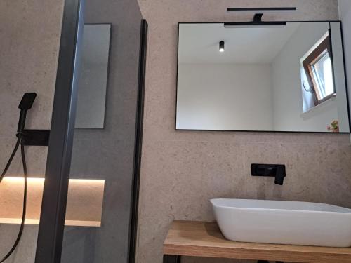 a bathroom with a white sink and a mirror at Holiday Home Domina in Sinj