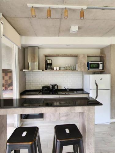 a kitchen with a counter and two stools in it at Complejo 42 in Mar Azul