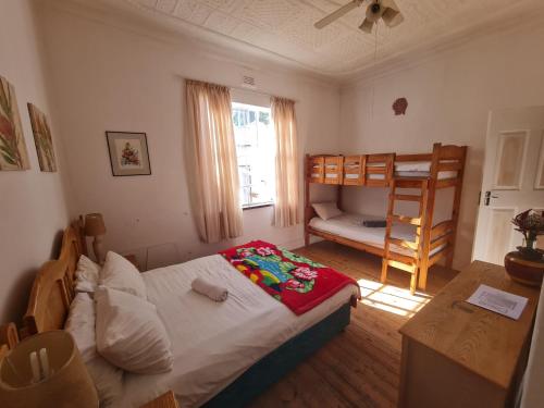 um pequeno quarto com uma cama e um beliche em Melville House em Joanesburgo