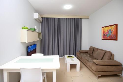 a living room with a couch and a table at Diamond Hill Resort & SPA in Vlorë