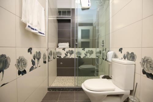 a bathroom with a toilet and a glass shower at Diamond Hill Resort & SPA in Vlorë