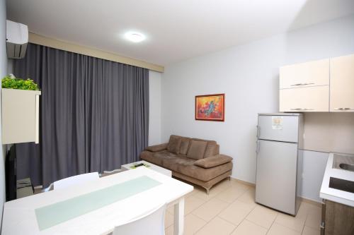 a small living room with a couch and a kitchen at Diamond Hill Resort & SPA in Vlorë