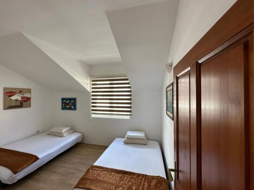 Habitación pequeña con 2 camas y ventana en Apartments Sun House, en Herceg-Novi