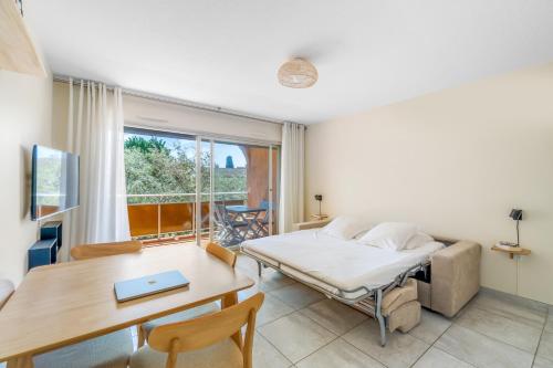 a bedroom with a bed and a desk and a table at Eden Azur - Résidence Hôtelière in Golfe-Juan