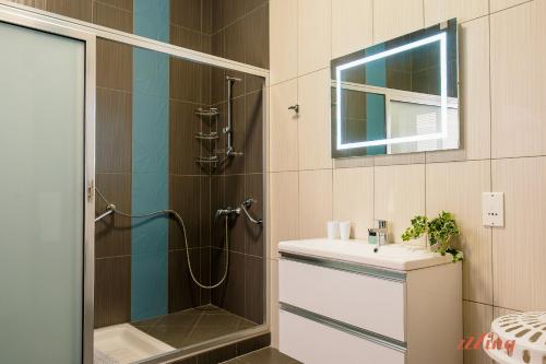 a bathroom with a shower and a sink and a mirror at Live like a rockstar in this luxury home in Siġġiewi