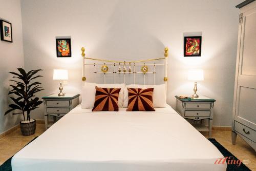 a bedroom with a large white bed with two night stands at Live like a rockstar in this luxury home in Siġġiewi