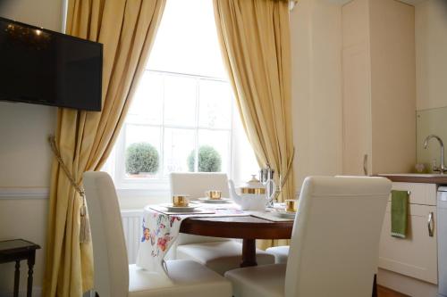 a dining room with a table and chairs and a window at Pier View Self Catering Luxury Apartments in Southend-on-Sea