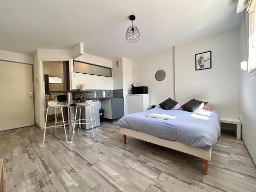 a bedroom with a large bed and a kitchen at Gabriel - B - Studio plein centre ville in Clermont-Ferrand