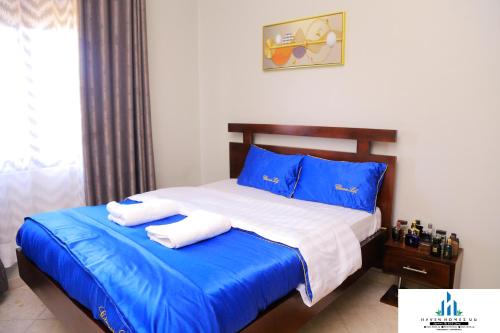 KyambogoにあるHaven Homes Ug H07 confy stayのベッド(青と白のシーツ、青の枕付)