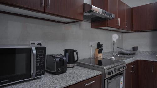 a kitchen with a microwave oven and a counter top at Anisa Residential Complex in Salalah