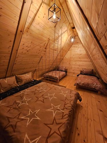 sypialnia z 2 łóżkami na drewnianym poddaszu w obiekcie Oaza Jela w mieście Mitrovac