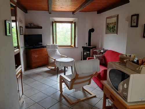 a living room with a red couch and chairs at Appartamento La Volpe in Pian degli Ontani