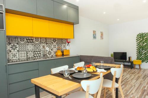 a kitchen with a table and chairs and yellow cabinets at Host Wise - Amadeo Apartments in Vila Nova de Gaia