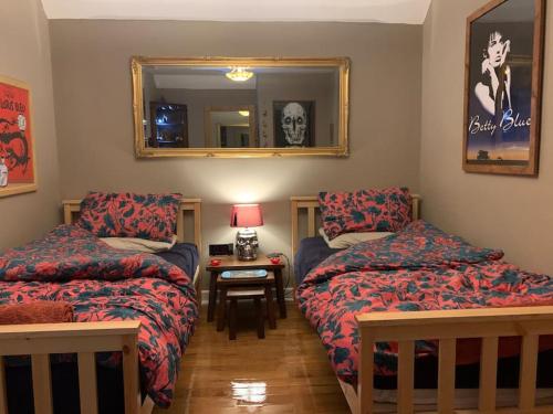 - une chambre avec 2 lits et une table avec un miroir dans l'établissement Bear Cottage, Tyn Y Cwm, à Scyborycoed