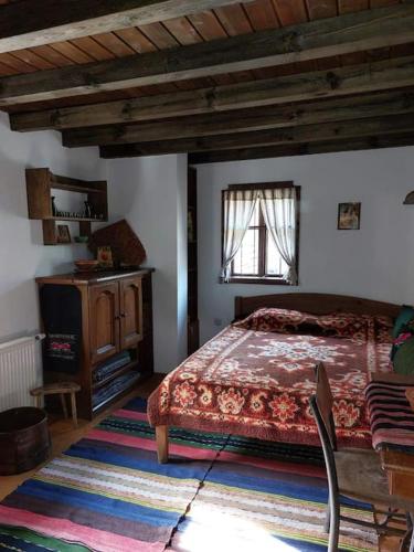 a bedroom with a bed and a table and a window at Къща за гости КИМ in Apriltsi