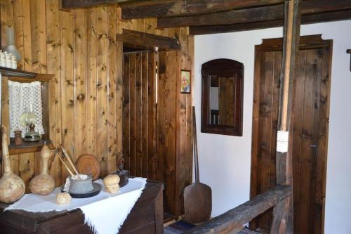 Cette chambre est dotée de murs en bois et d'une table avec des vases. dans l'établissement Къща за гости КИМ, à Apriltsi