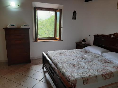 Un dormitorio con una cama grande y una ventana en Appartamento La Volpe, en Pian degli Ontani