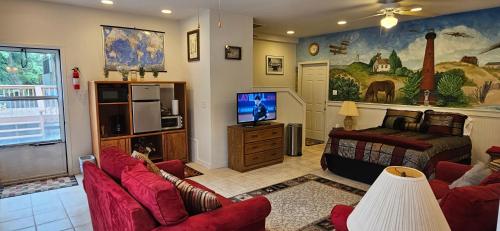 sala de estar con muebles de color rojo y TV en KD by the Sea en Kitty Hawk