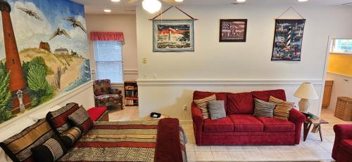 a living room with a red couch and a chair at KD by the Sea in Kitty Hawk