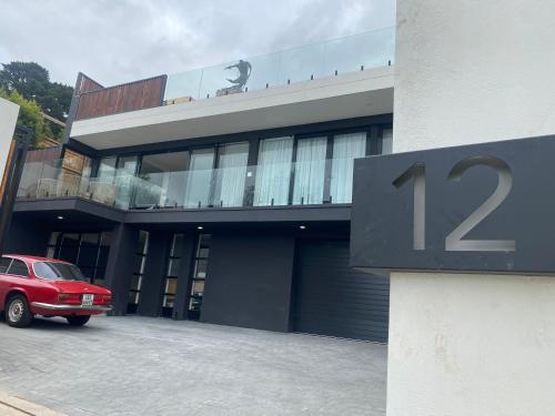 a red car parked in front of a building at Constantia View Apartments- Luxury Self Catering in Cape Town