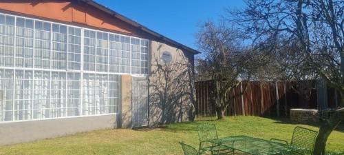 a building with a fence next to a yard at Green Thumb Farm Stay in Ermelo