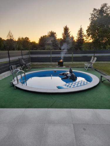a person laying in a pool with a fire pit at Wypoczynek nad Dunajcem in Jurków