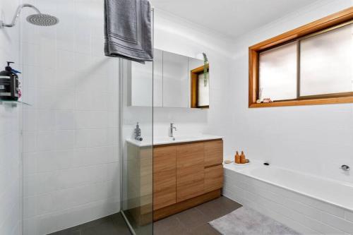 a bathroom with a shower and a tub and a sink at Valley View Home - 3 Bdrms, Bay Views, Woodfired Pizza Oven, Firepit in Port Lincoln